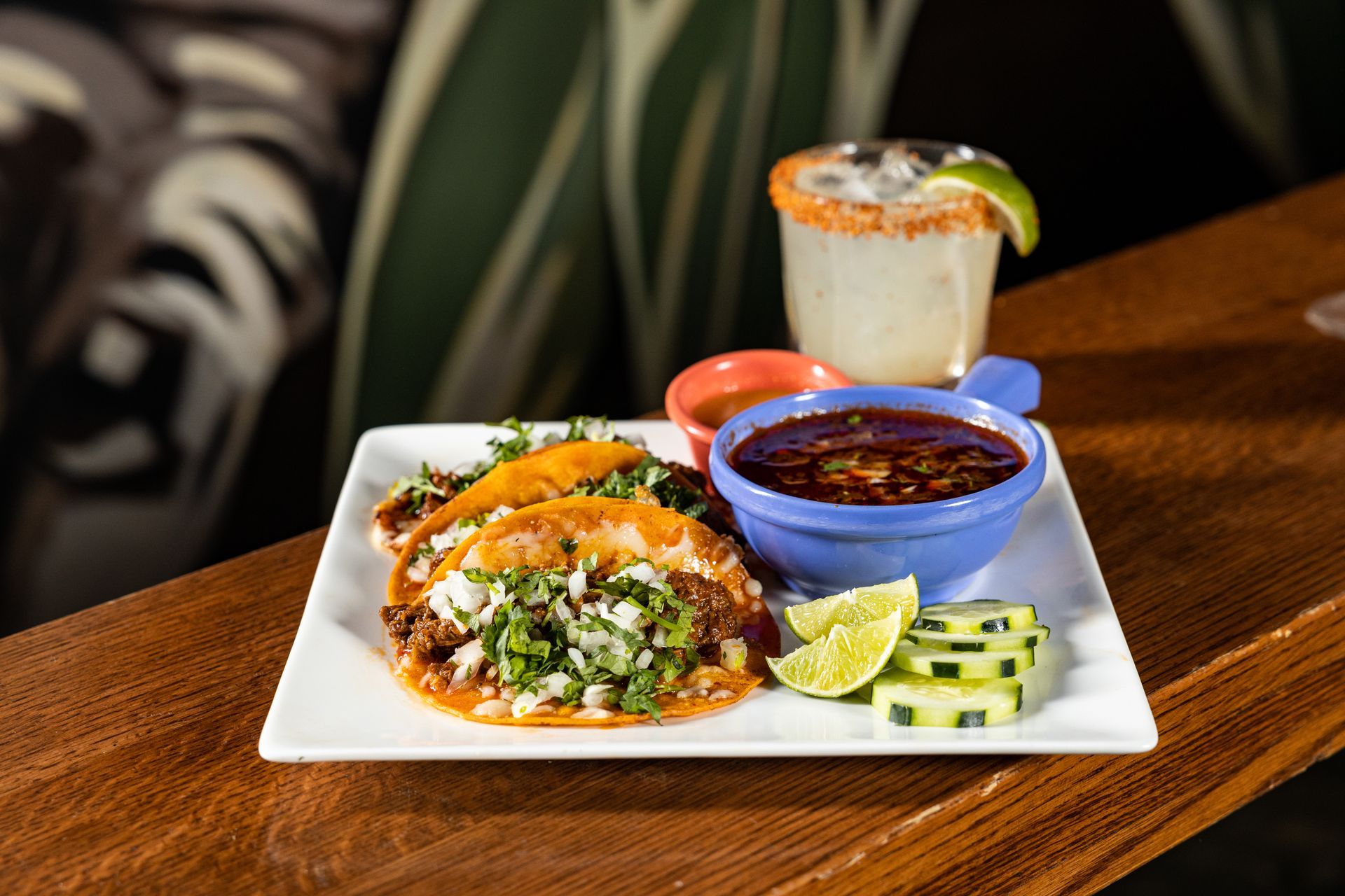 A plate of food with a drink on a table at con safos in denver colorado near coors field