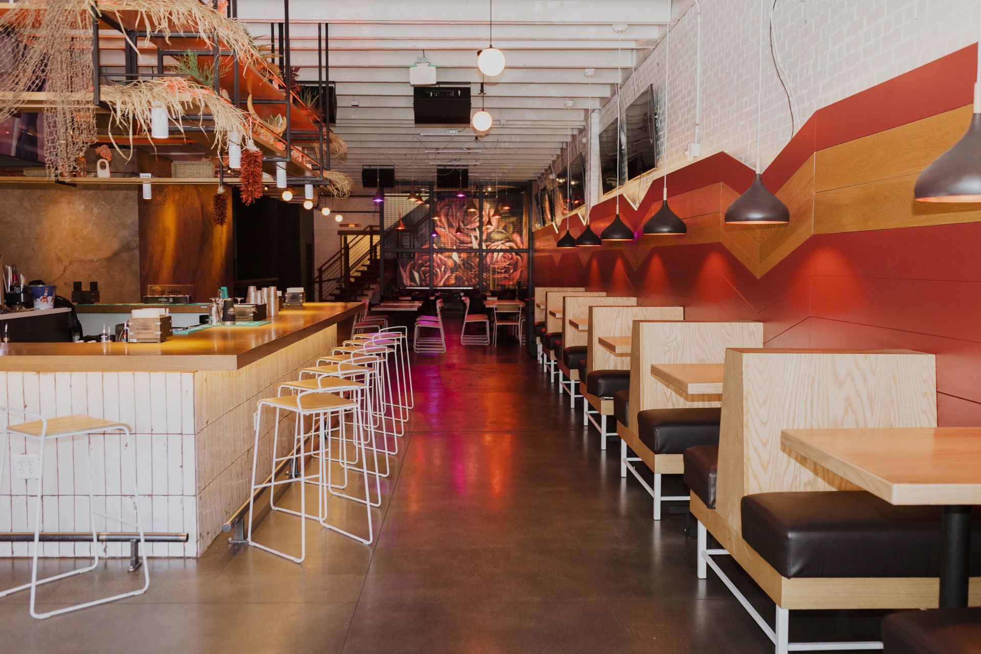 A restaurant with tables and benches and a bar at con safos in denver colorado, located near coors field