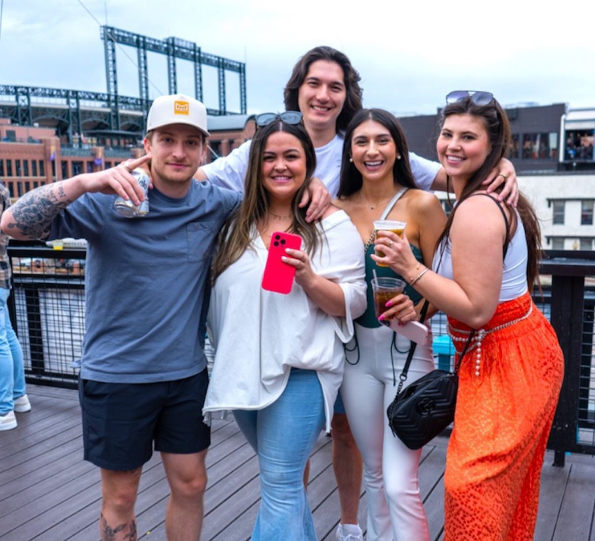 A group of people posing for a picture on a deck at el patio in denver colorado located near coors field