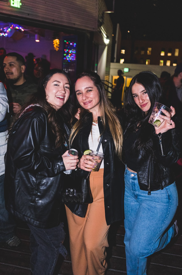 Three women are posing for a picture at a party while holding drinks at El Patio in denver colorado