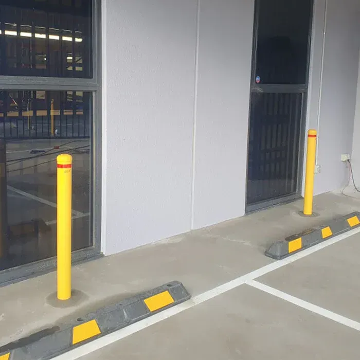 2 bollards installed at the end of a parking spot