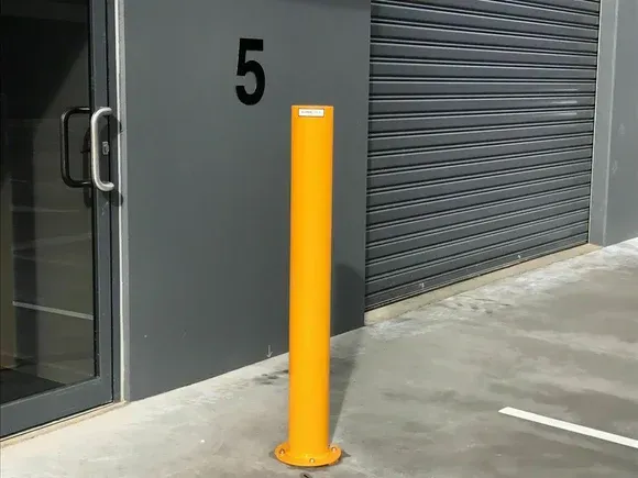 yellow bollard in front of a door