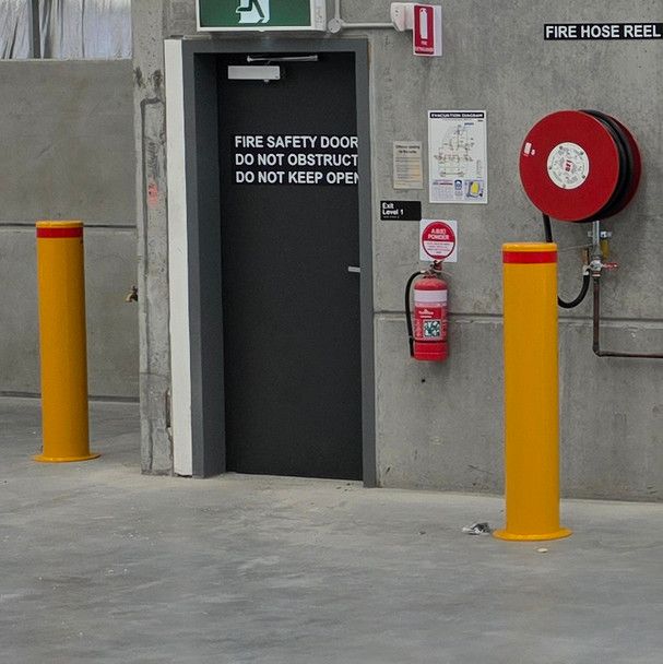 2 thick bollards installed next to the fire door