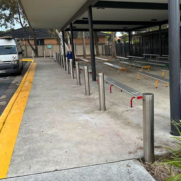 chrome gas bollards on a foot path next to the road