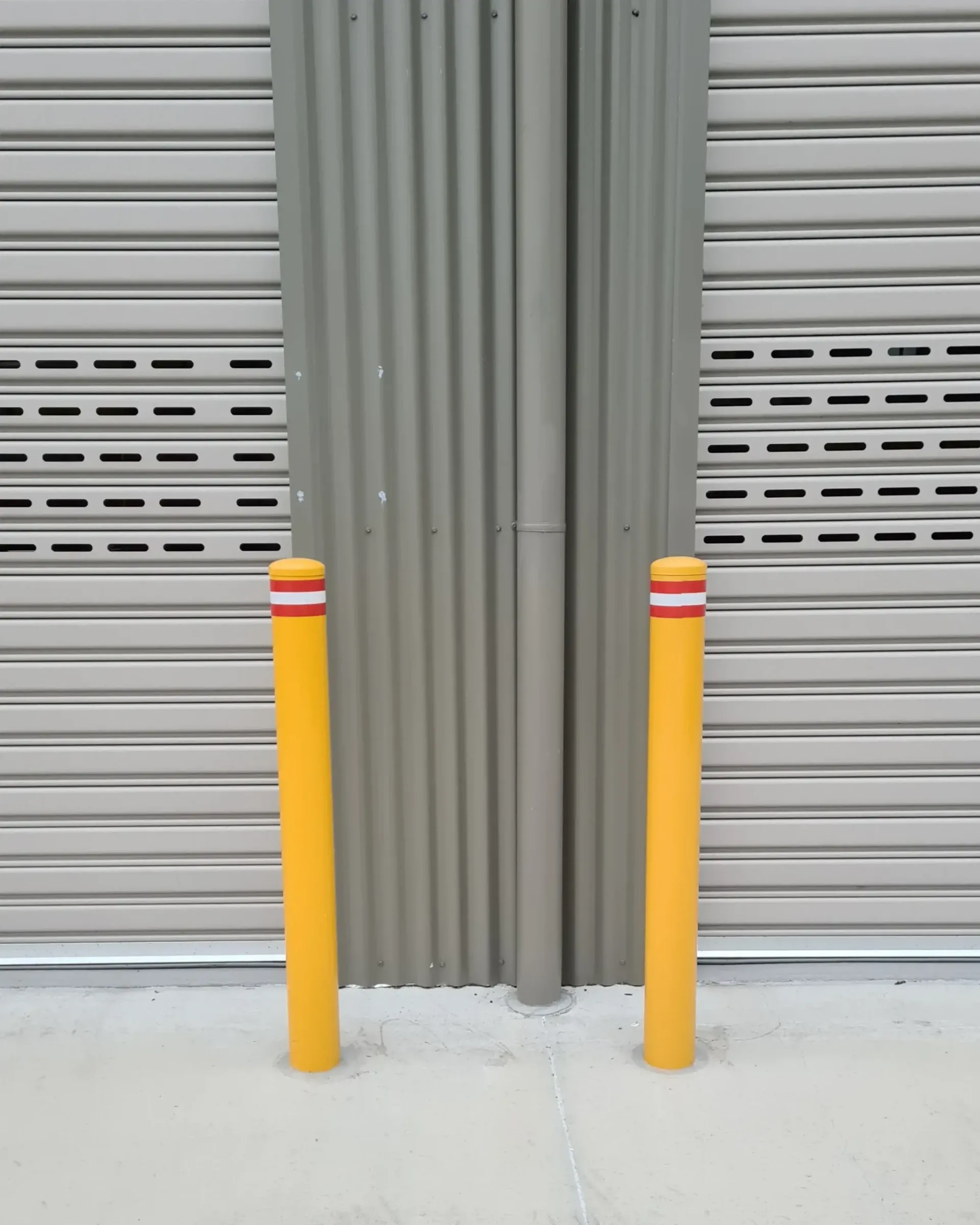 2 unground bollards in front of 2 roller doors