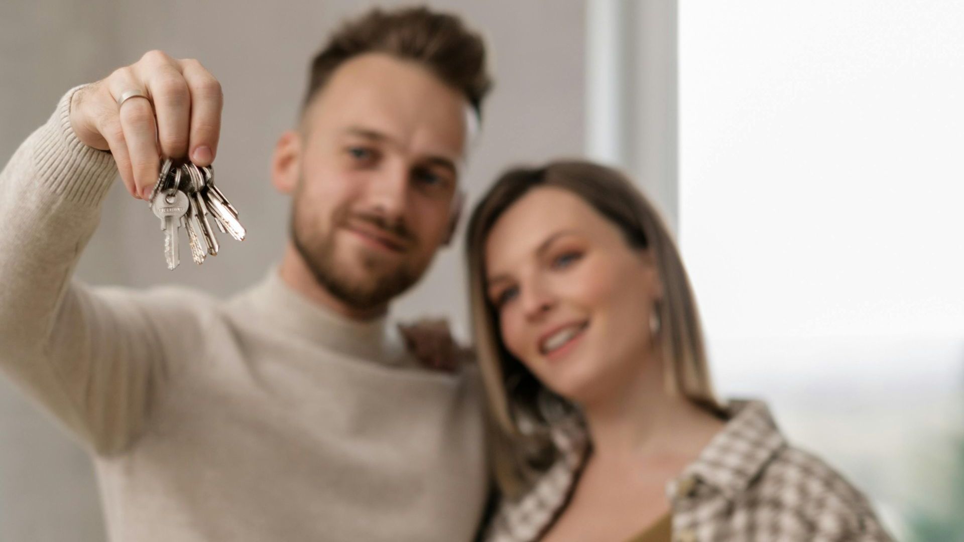 A man is holding a bunch of keys in front of a woman.