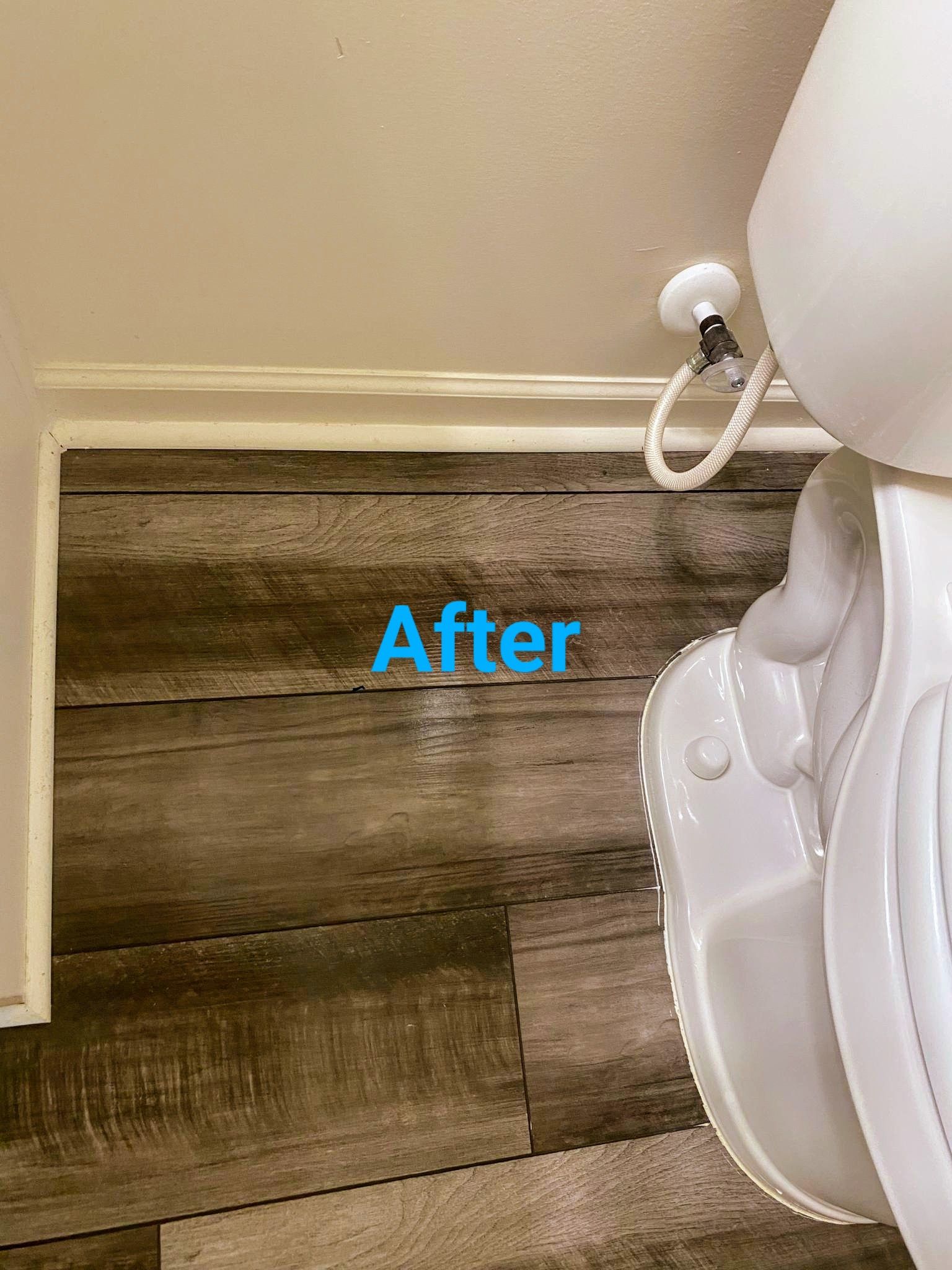 Bathroom with wood-look wall paneling, white toilet, and a toilet paper holder. 