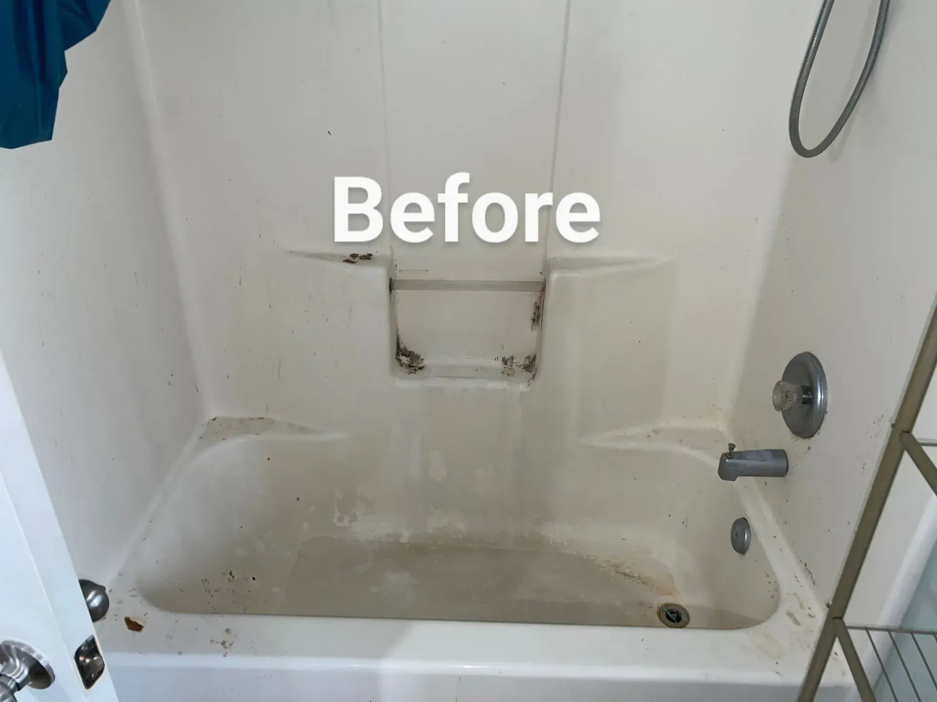 Dirty, off-white bathtub with brown stains and debris. A shower head and faucet are visible. The word 