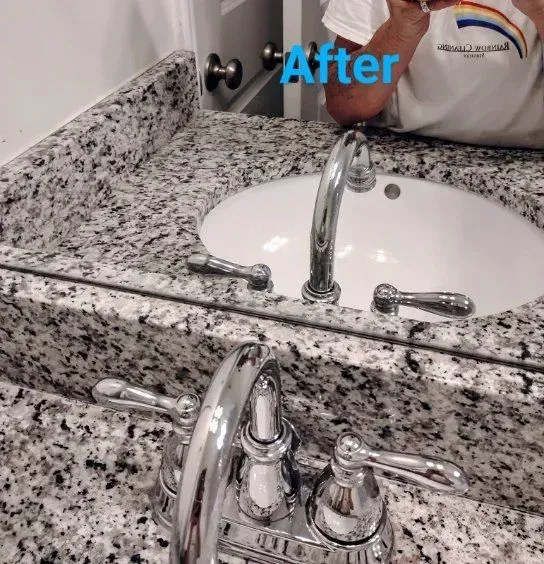 Bathroom sink with granite countertop and chrome faucet.