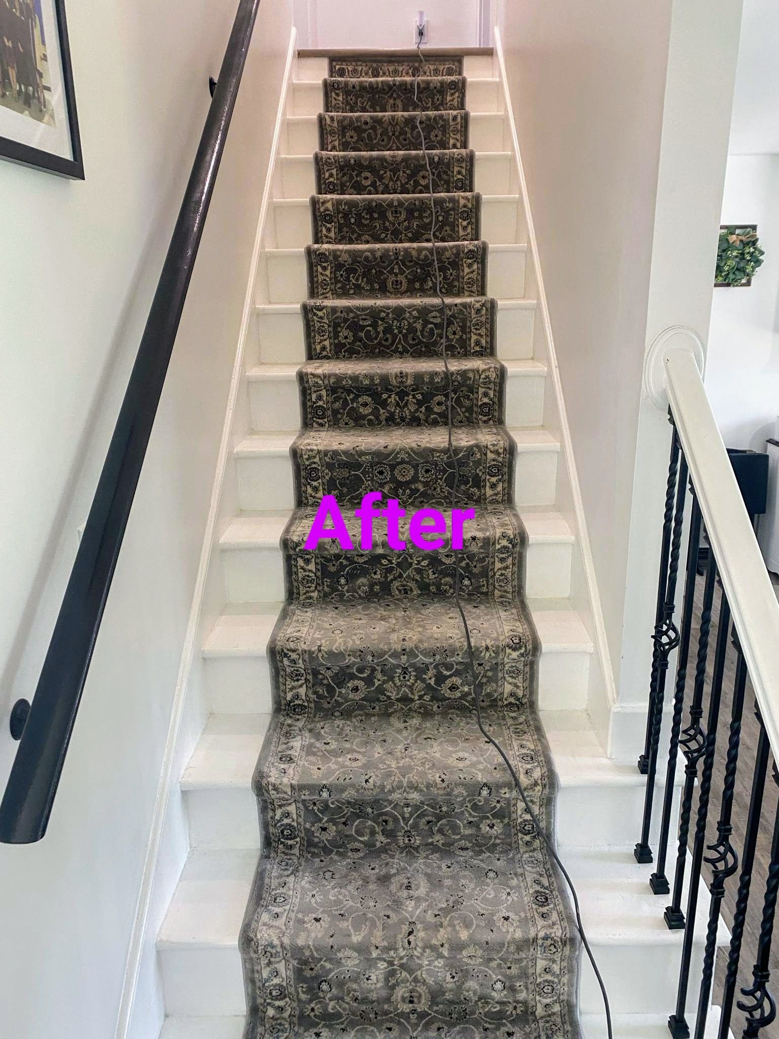 A staircase with a carpet runner and white painted risers and stringers; the word 