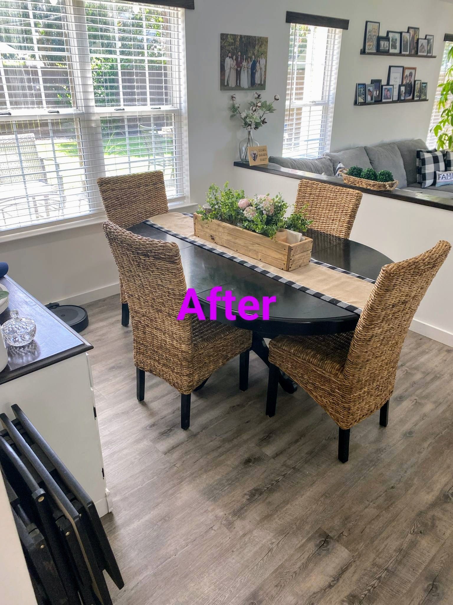Dining room with oval table, four woven chairs, centerpiece, and window. 
