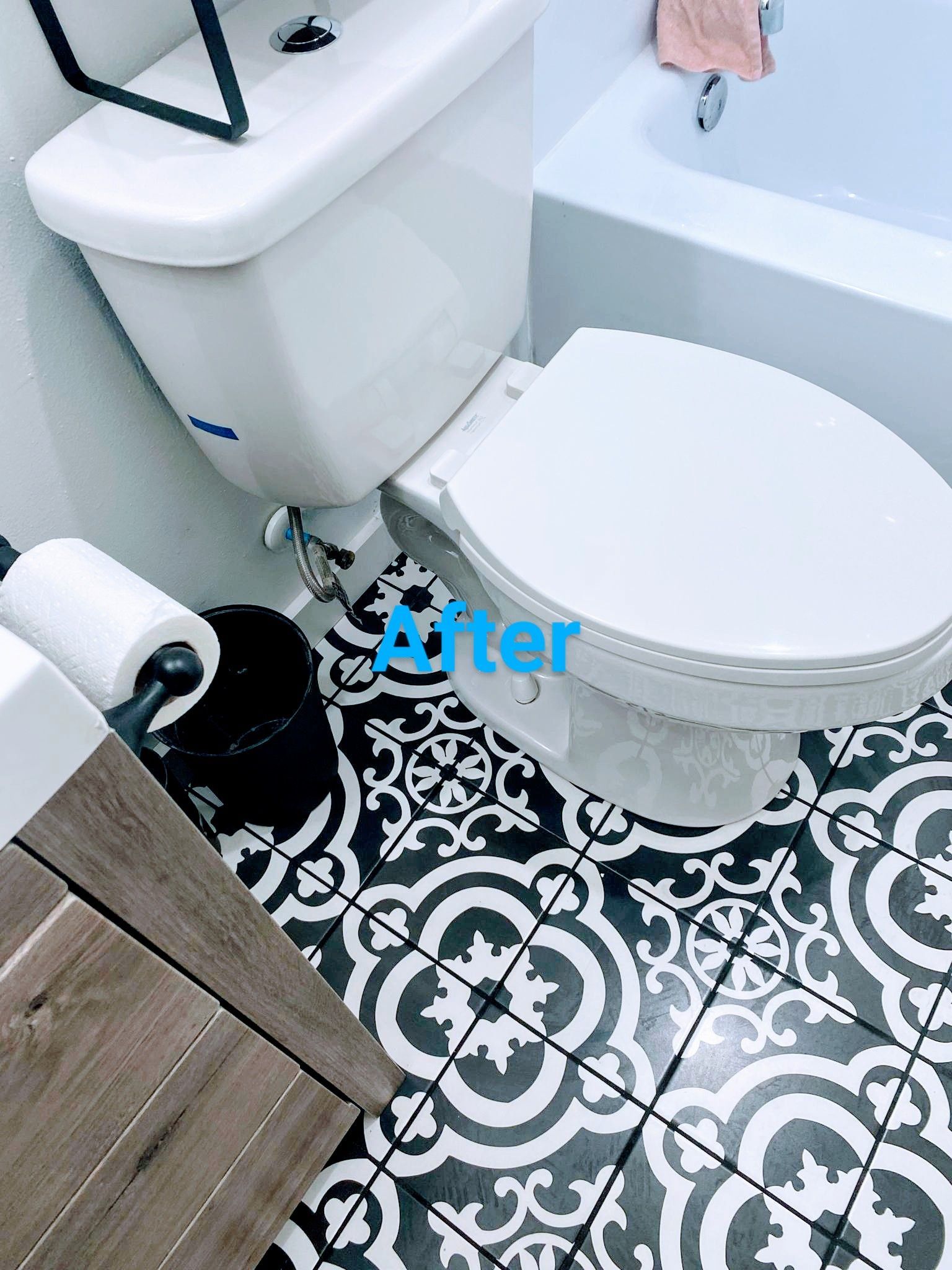 Bathroom with a white toilet, black and white patterned floor, and a wooden cabinet.