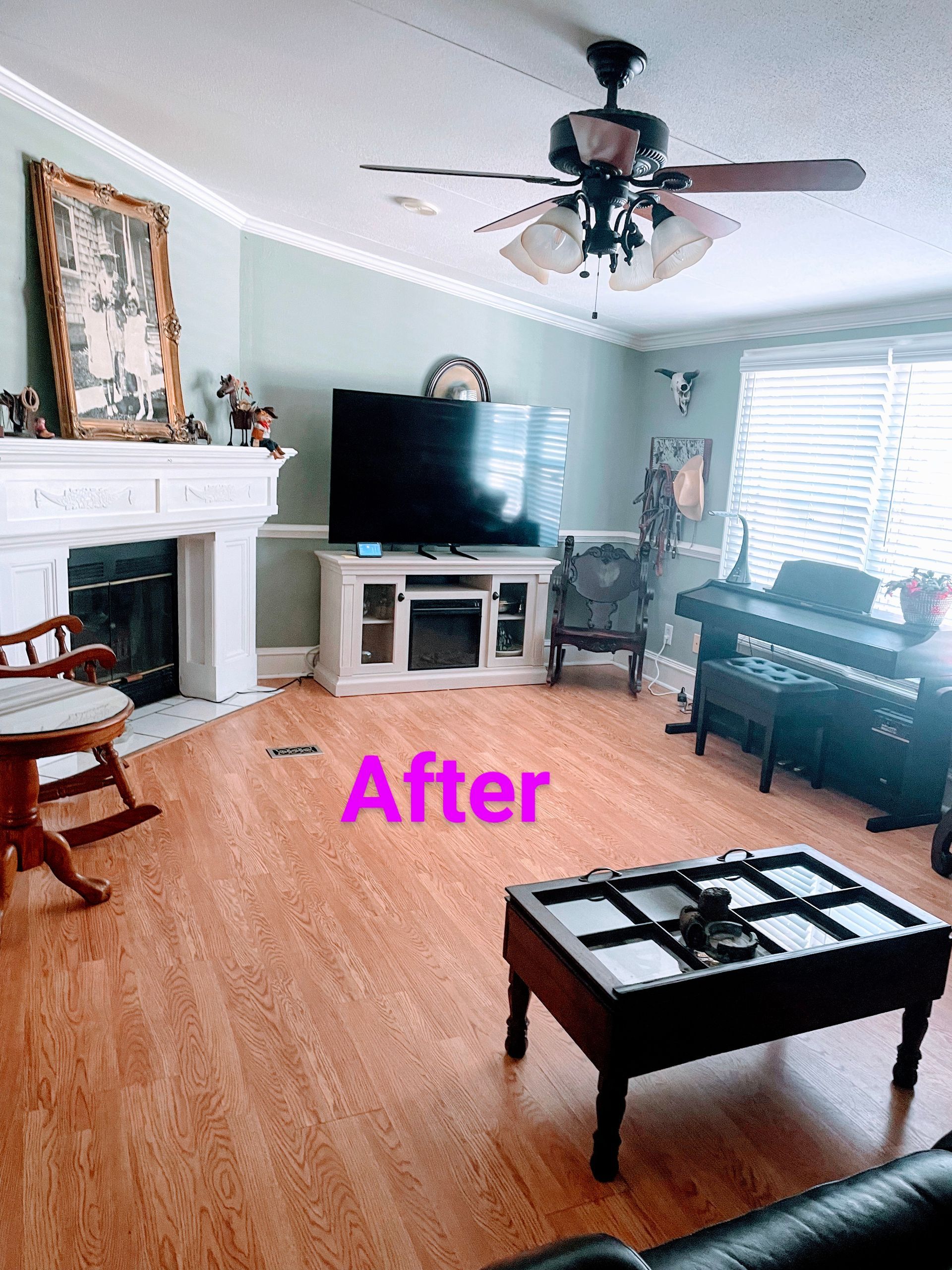 Living room with a fireplace, TV, piano, and coffee table; hardwood floors and green walls.