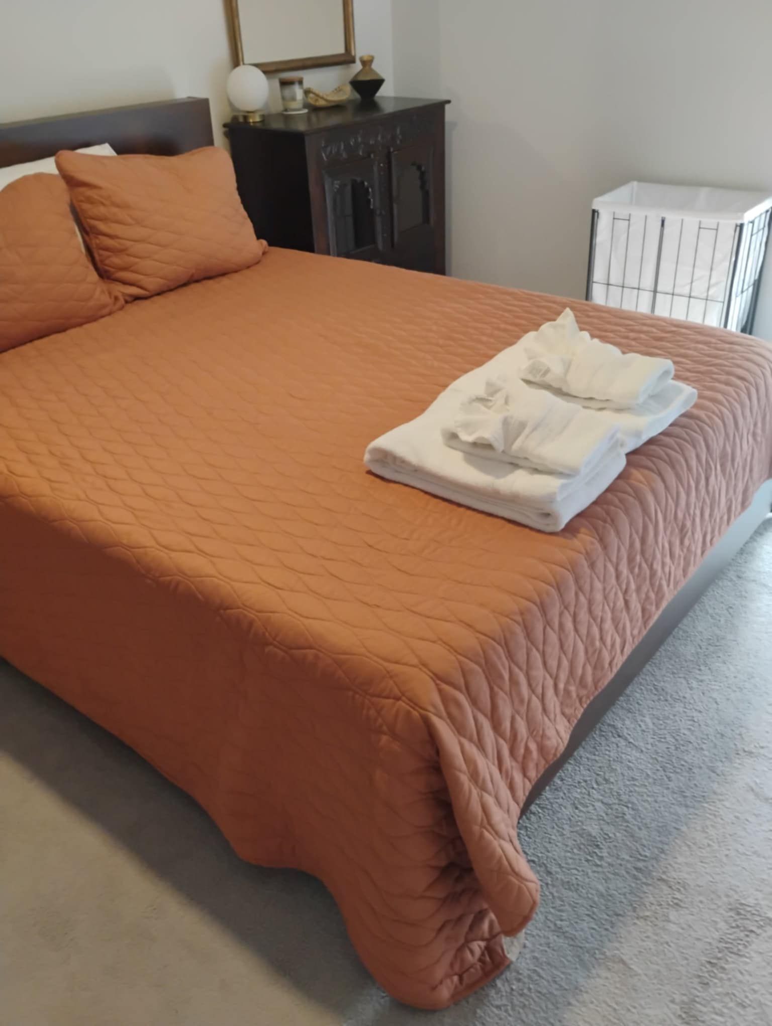 A bed with a quilt and towels on it