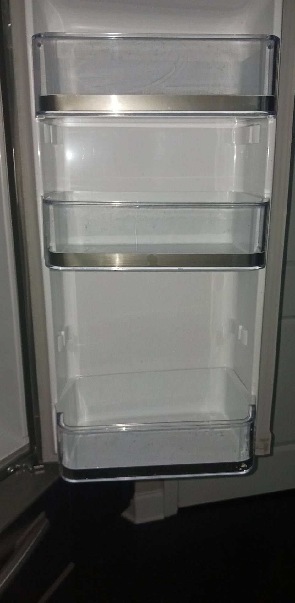 The inside of an empty refrigerator with the door open.