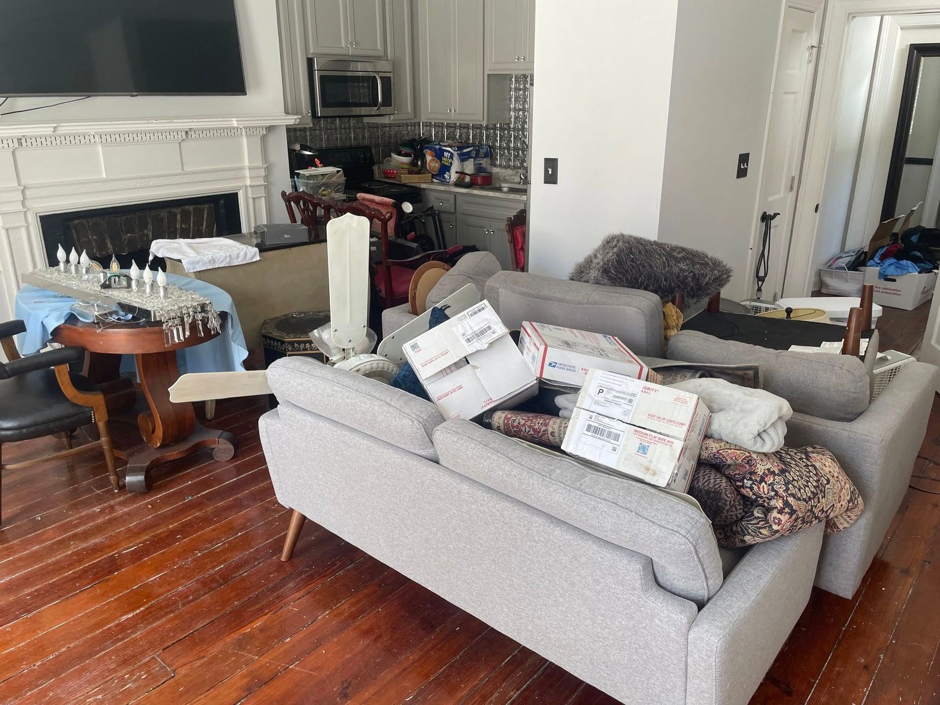 A living room with a lot of furniture and boxes on the floor