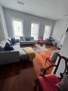 A living room with a couch , chairs , and a table.