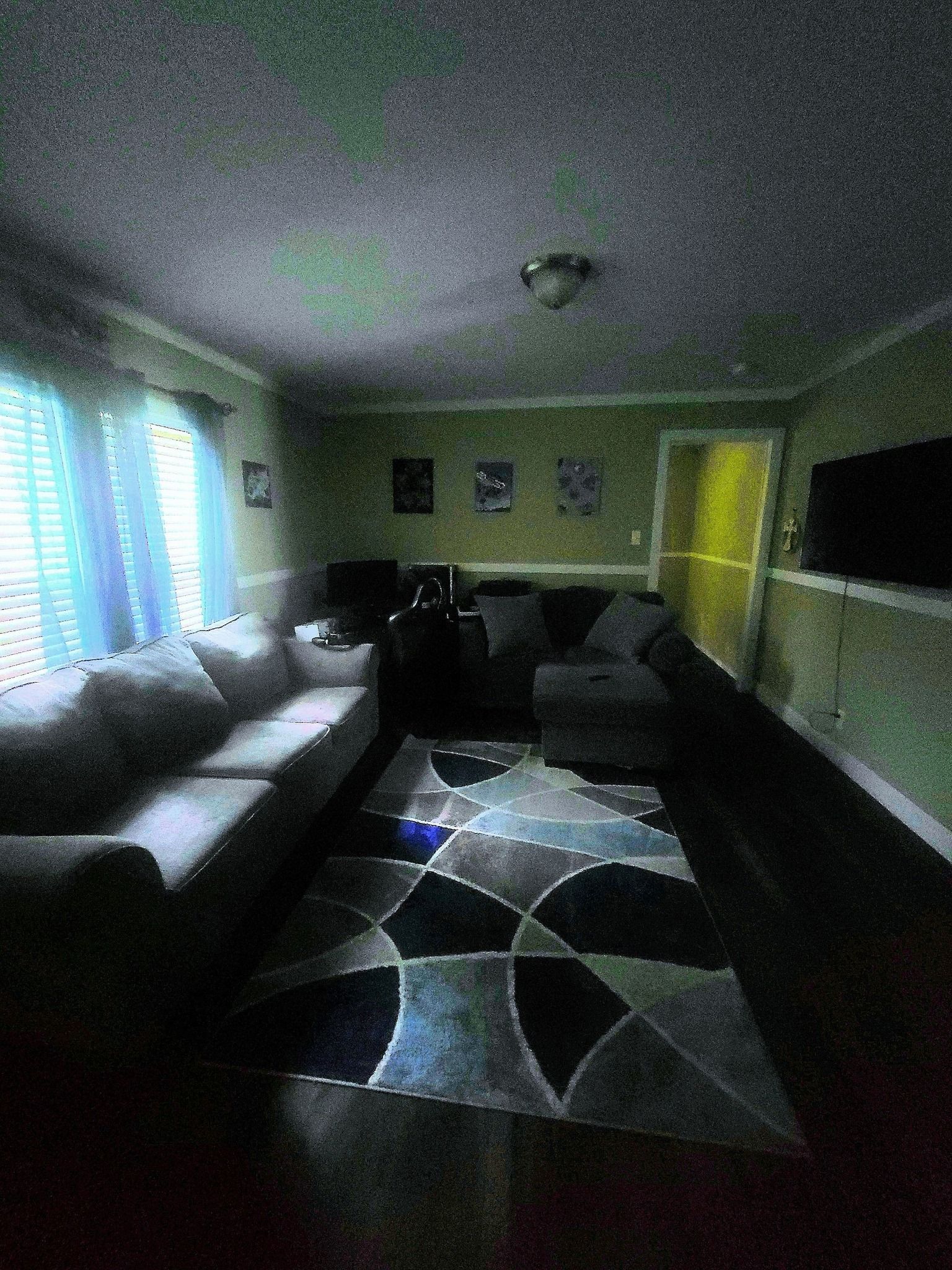 A living room with a couch , chairs , and a rug.