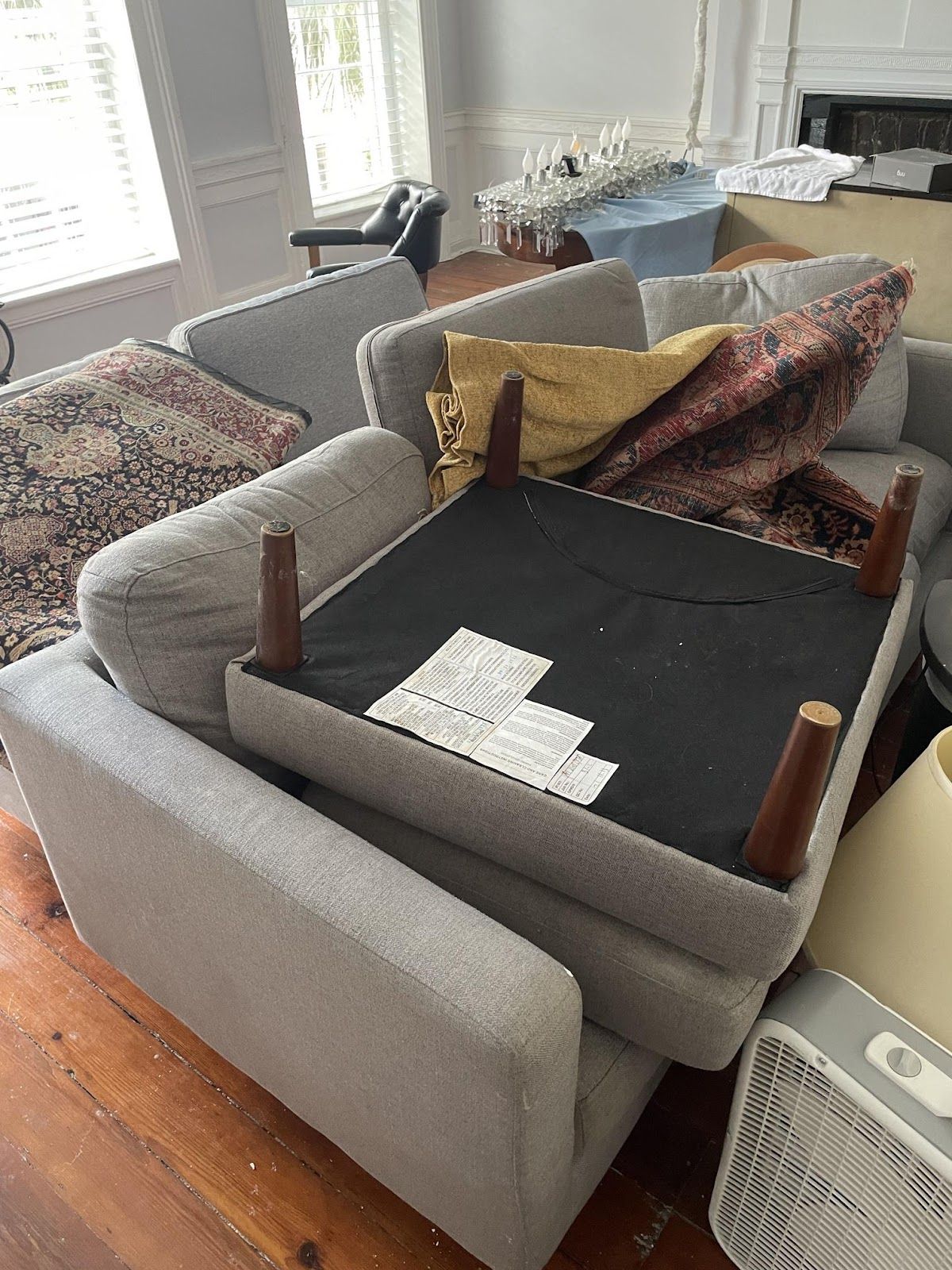 A couch is sitting on top of another couch in a living room.
