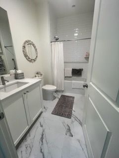 A bathroom with a toilet , sink , and bathtub.