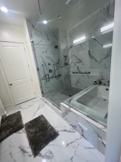 A bathroom with a tub , shower , and mirror.