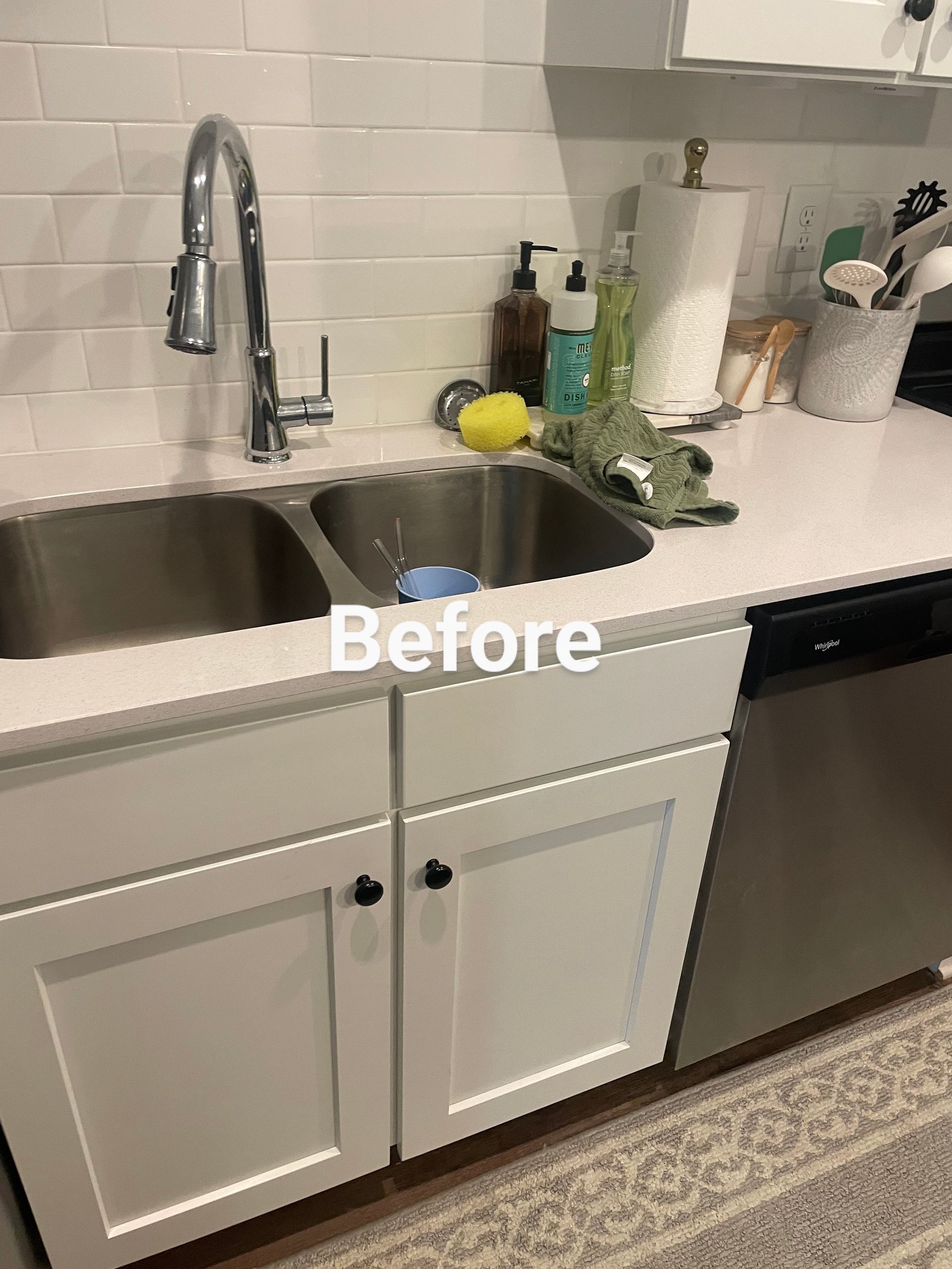 White kitchen sink with faucet, countertop clutter, and dishwasher, labeled 