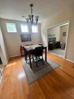 A dining room with a table and chairs and a chandelier.