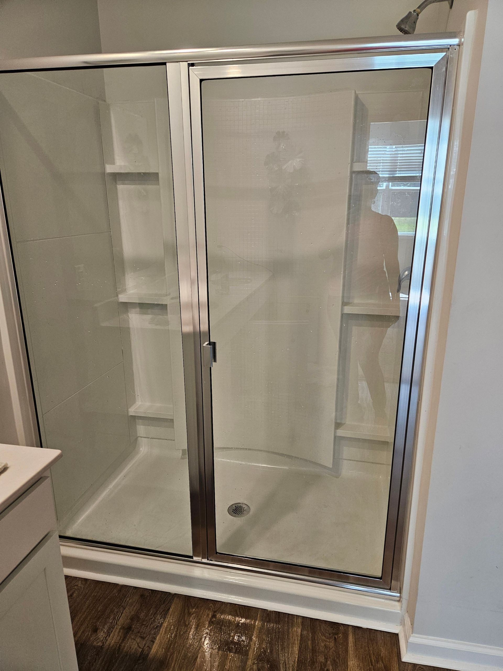 A bathroom with a sliding glass shower door and a sink.