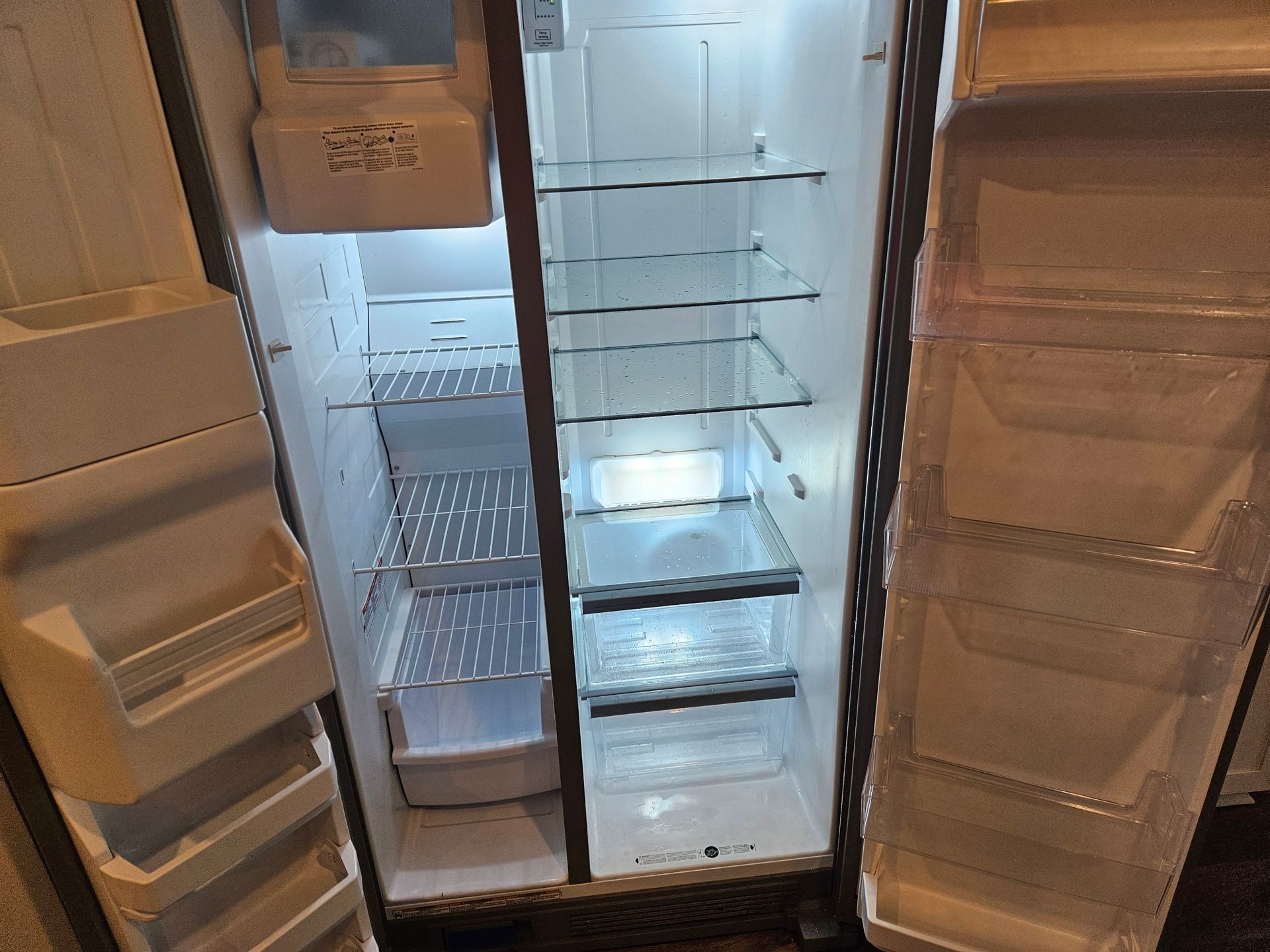 The inside of an empty refrigerator with the door open.