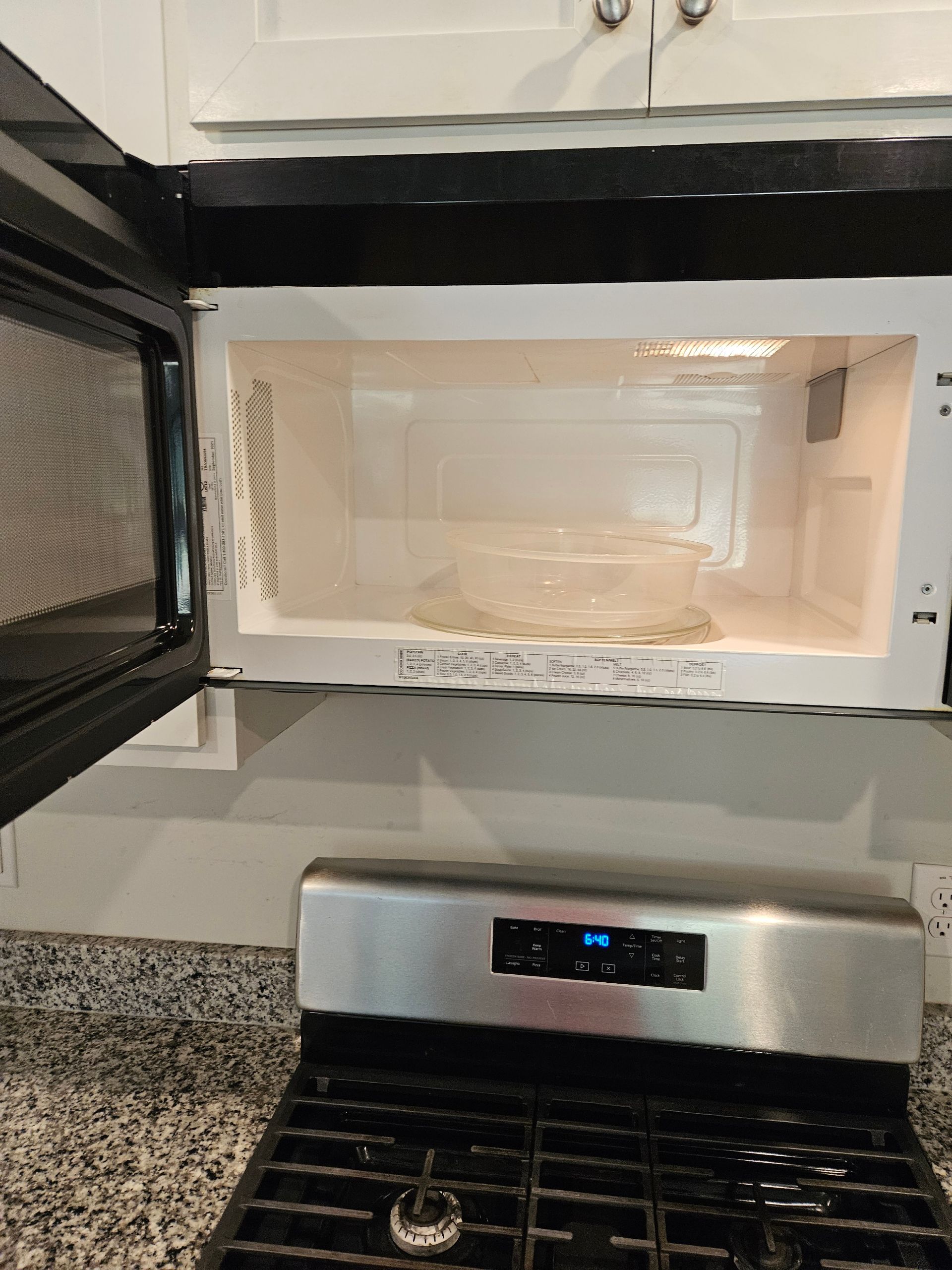 A microwave oven is sitting on top of a stove in a kitchen.