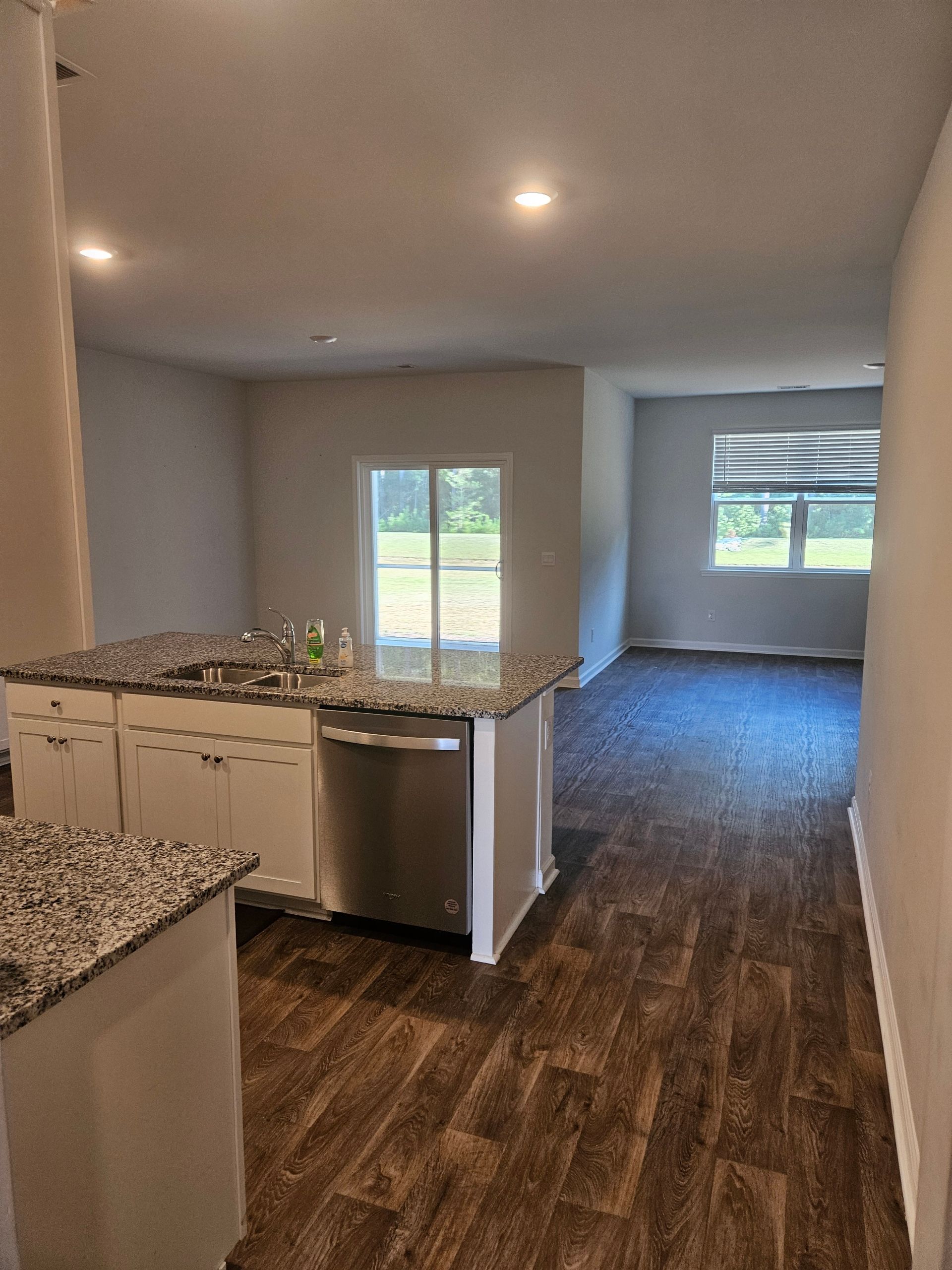 A kitchen with granite counter tops and a stainless steel dishwasher.