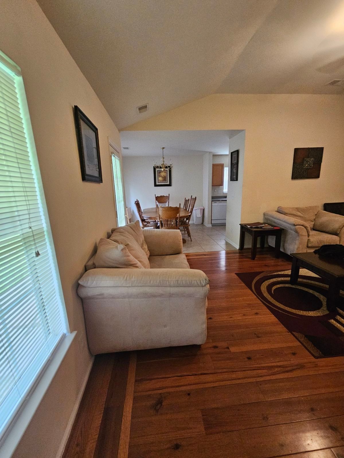 A living room with a couch , chair , table , and rug.
