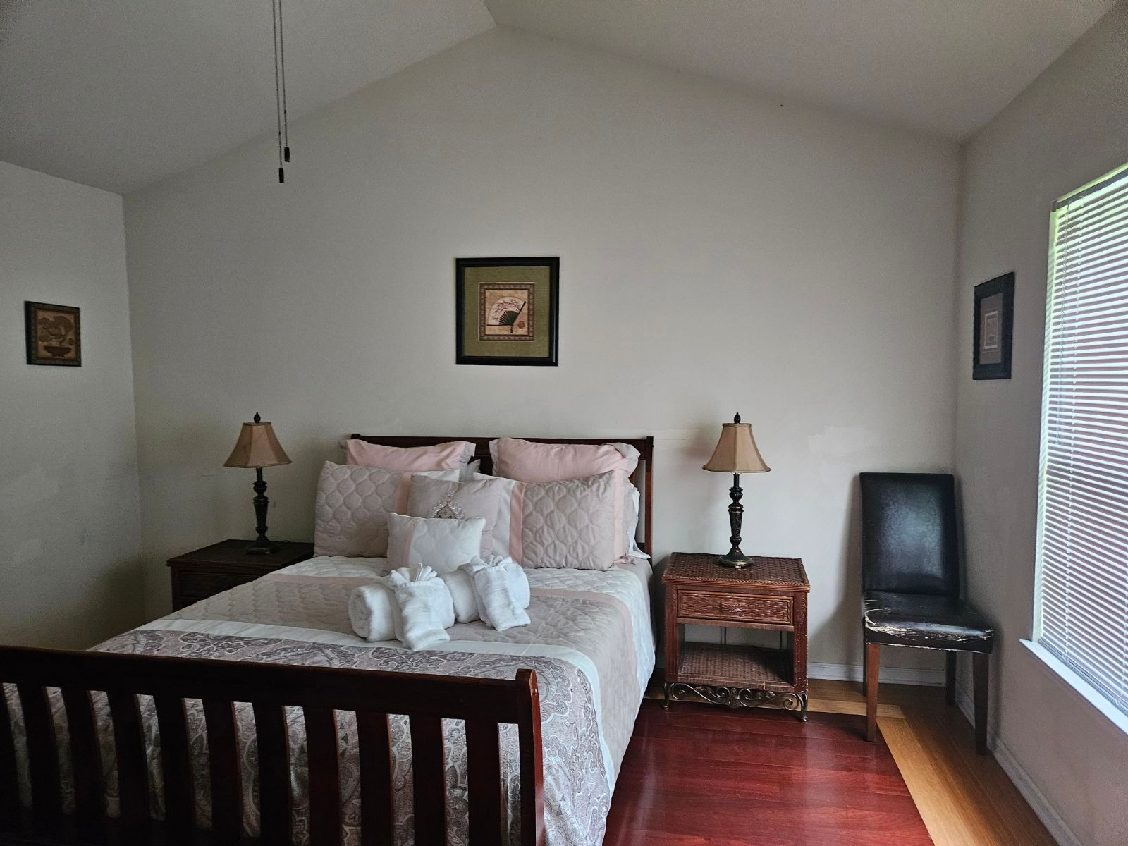 A bedroom with a large bed and two lamps