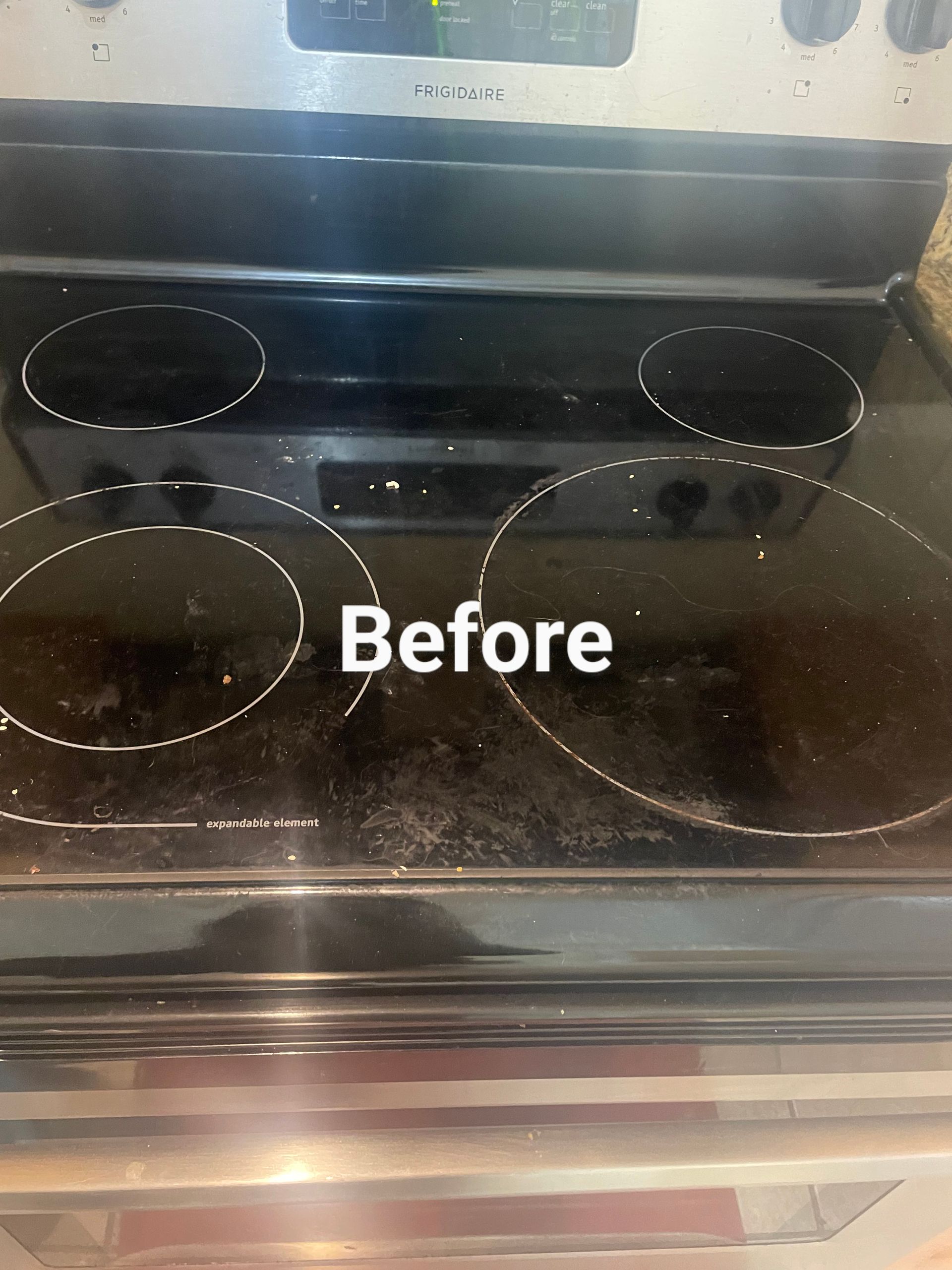 Dirty black electric stovetop labeled 