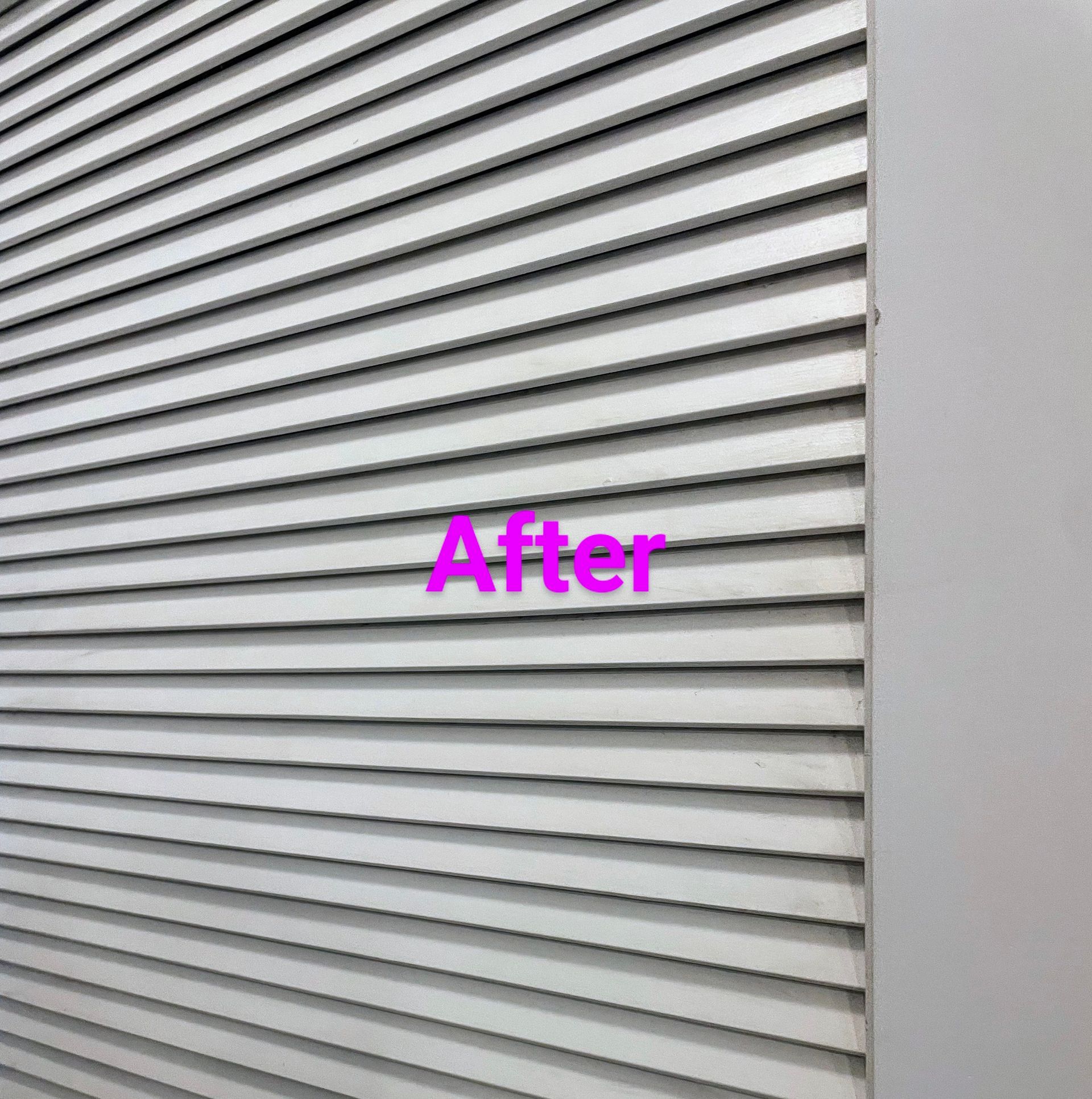 Gray, horizontal slat blinds with the word 