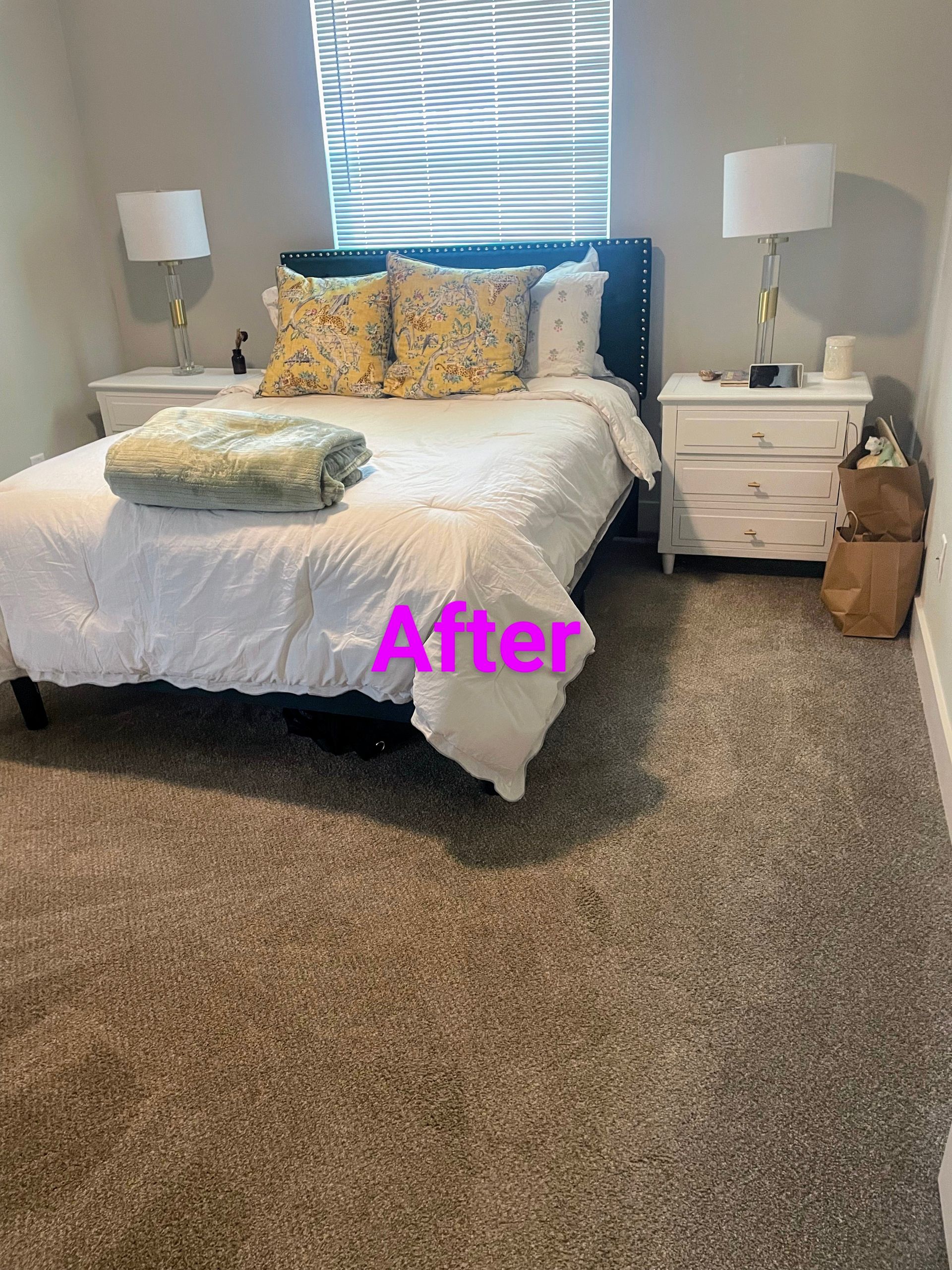 Bedroom with bed, nightstands, lamps, and carpet. 