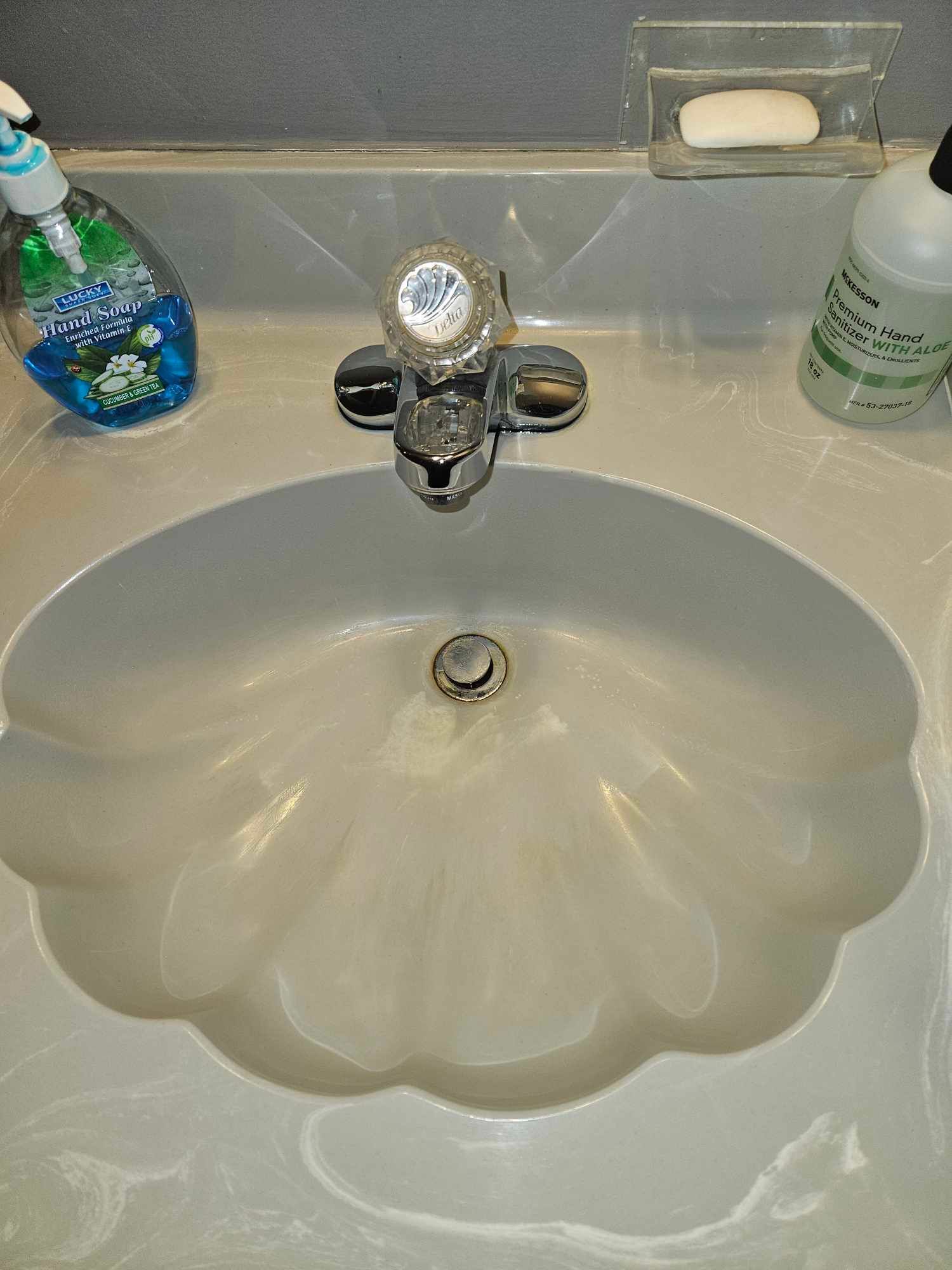 A bathroom sink with a soap dispenser and a soap bar