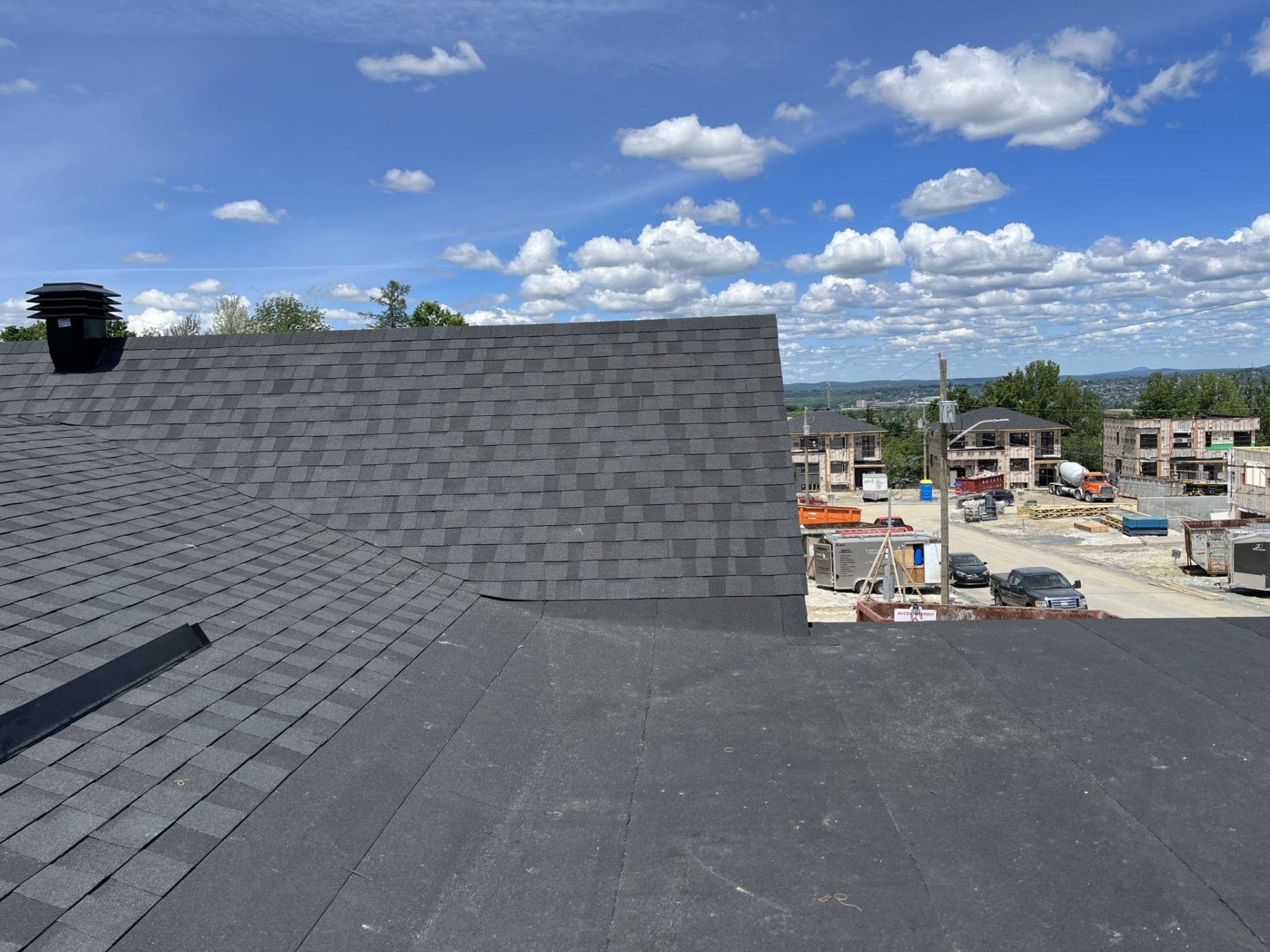 Un toit surmonté d'une cheminée et une vue sur une ville.