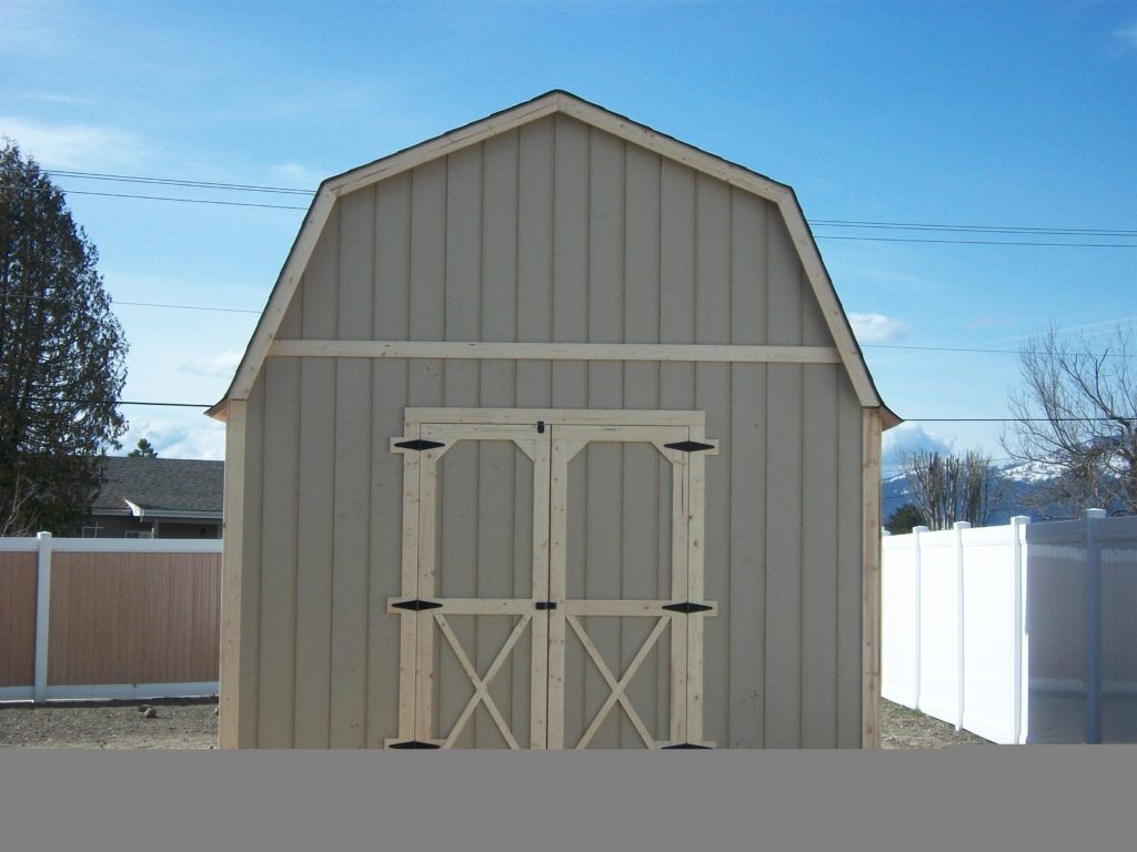 A barn with a white fence in front of it