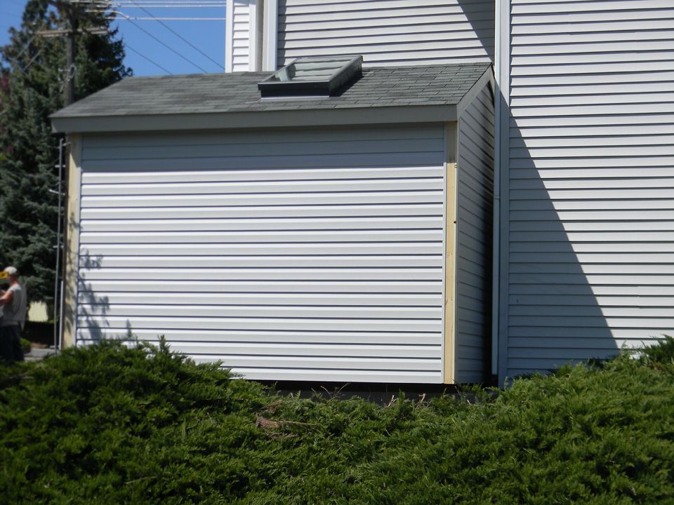 A white house with a shed on the side of it