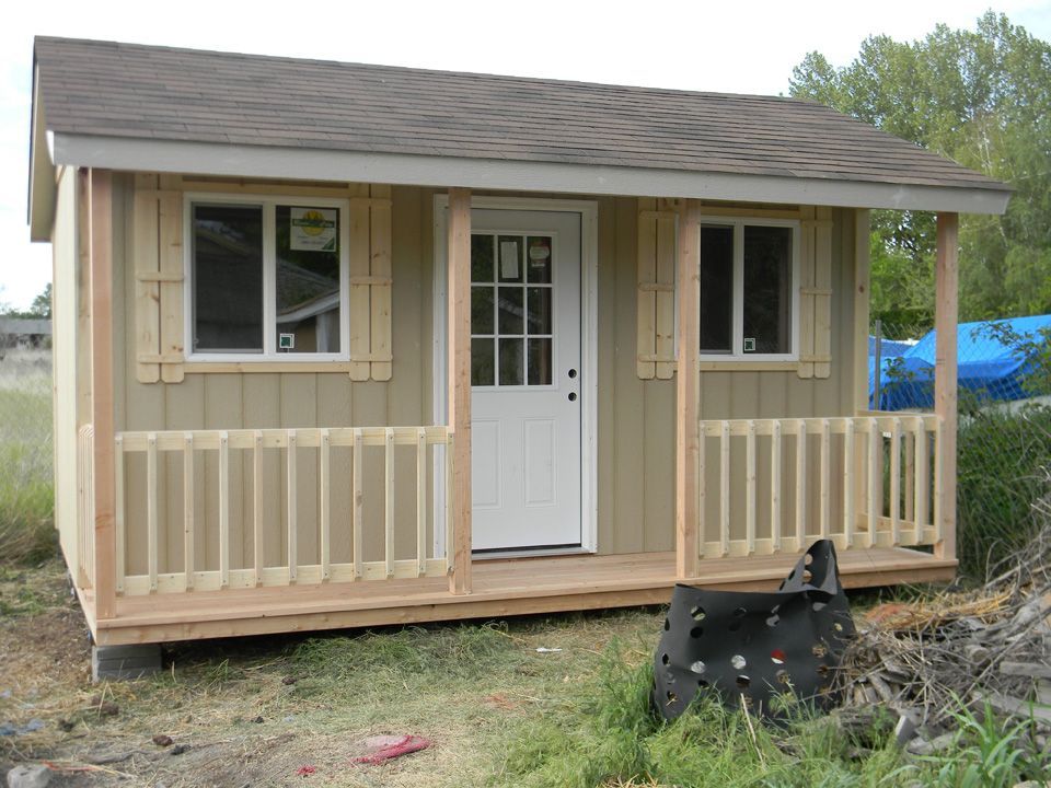 A small house with a porch and two windows