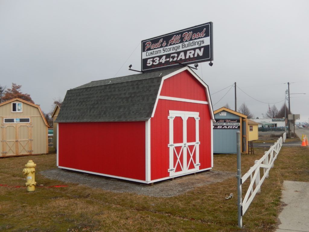 A red barn with a sign above it that says ' sheds for rent '