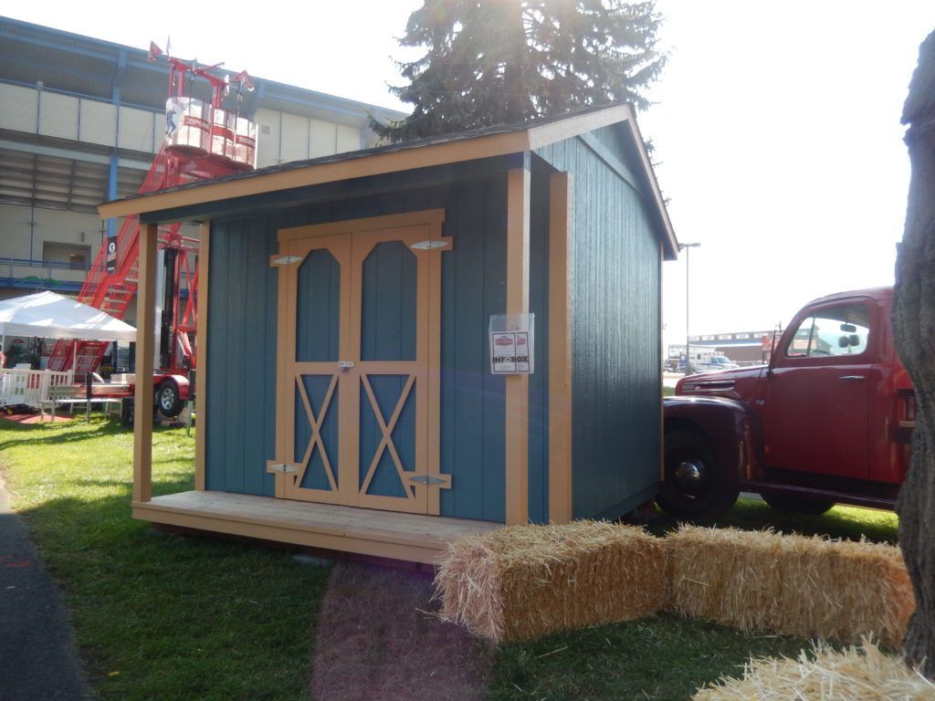 A red truck is parked next to a blue shed
