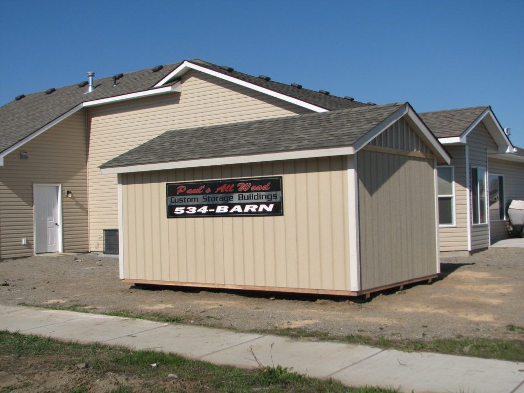 A shed in front of a house with a sign that says r34 barn
