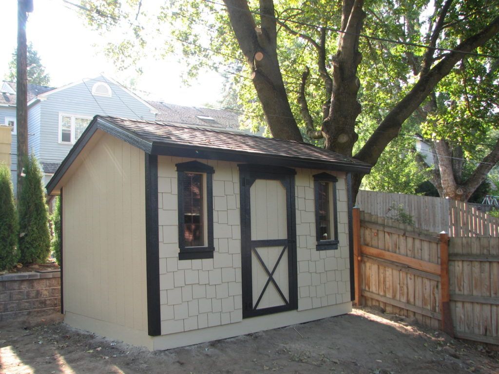 A small shed with a fence in front of it