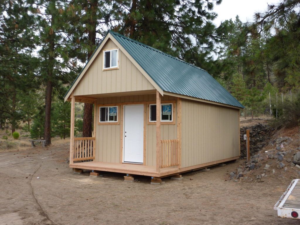A small house with a metal roof and a porch