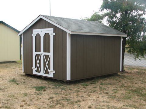 A brown and white shed with a roof and a door