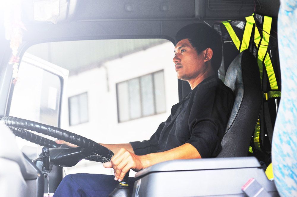 A Man Is Sitting In The Driver's Seat Of A Truck — Snap Crane Truck Hire in Coffs Harbour, NSW