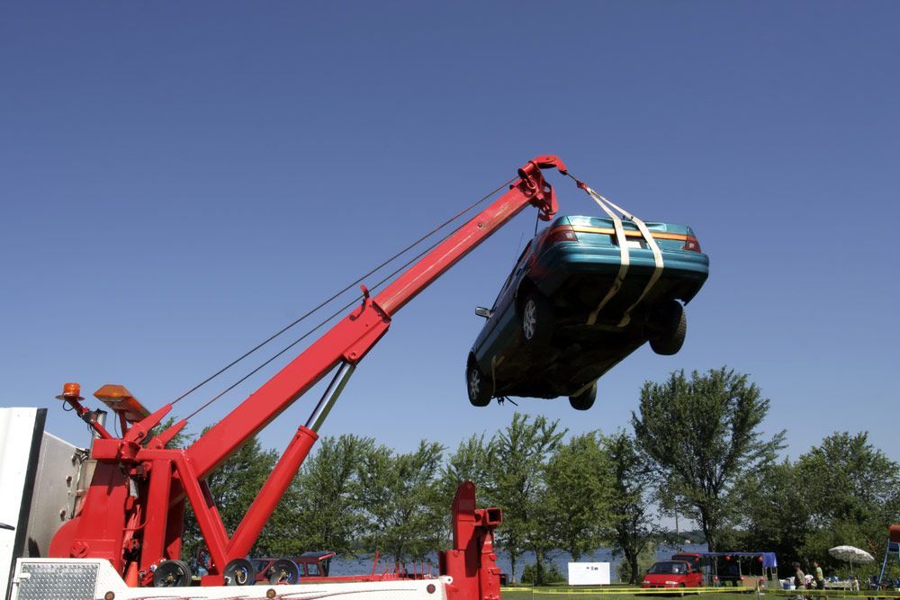 A Blue Car Is Being Lifted By A Tow Truck — Snap Crane Truck Hire in South Kempsey, NSW