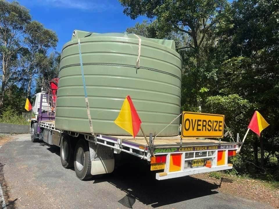 A Large Green Tank Is On The Back Of A Truck — Snap Crane Truck Hire in South Kempsey, NSW